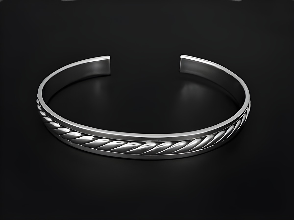 Silber Armreifen - 18 cm - trendig, Hersteller: Juwelier Harnisch, eleganter Armreif mit geflochtenem Design, glänzende Oberfläche auf schwarzem Hintergrund.