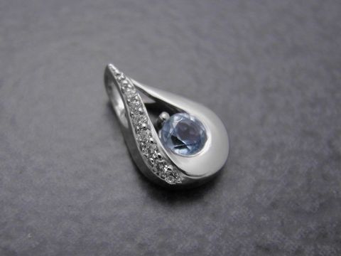 Anhänger in Tropfenform aus rhodiniertem Sterling Silber mit einem blauen Topas und Zirkonia, hergestellt von Juwelier Harnisch, edles Schmuckstück mit zusätzlichen Steinen.
