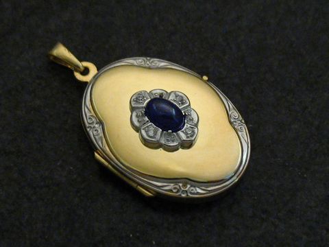 41529-0 Saphir blauer Medaillon Cabochon aus Gold 333 bicolor von Juwelier Harnisch, elegant gestaltet mit einem umrahmenden Schmuckstein und feinen Details, ideal für stilvolle Anlässe.