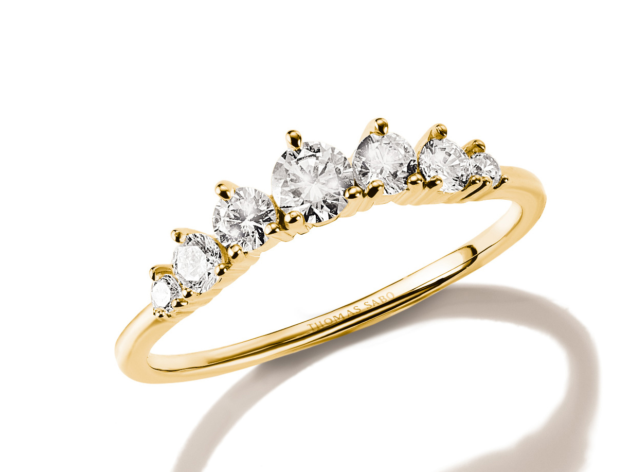 Goldfarbener Thomas Sabo Ring mit fünf weißen Zirkonia, die elegant in einer Reihe angeordnet sind. Der Ring hat eine Höhe von 5 mm und die Größe 52. Neuheit des Herstellers Thomas Sabo.