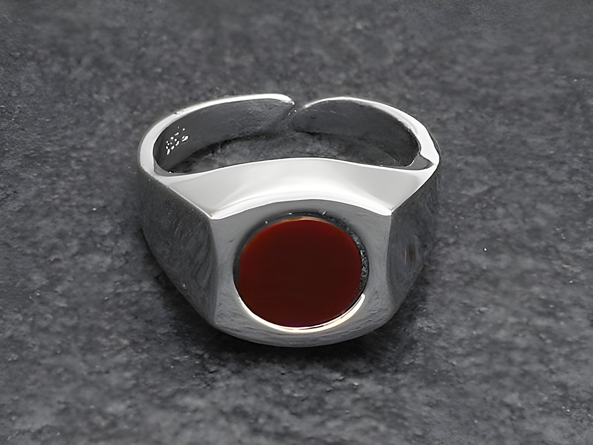 Schlichter Silberring in rhodiniertem Design mit verstellbarer Größe und einem runden Karneolstein in der Mitte, Hersteller Juwelier Harnisch.