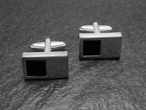 Designer Manschettenknöpfe in modernem Onyx-Look mit schwarzer Oberfläche und silberfarbenem Gestell, hergestellt von Juwelier Harnisch. Ideal für elegante Anlässe.