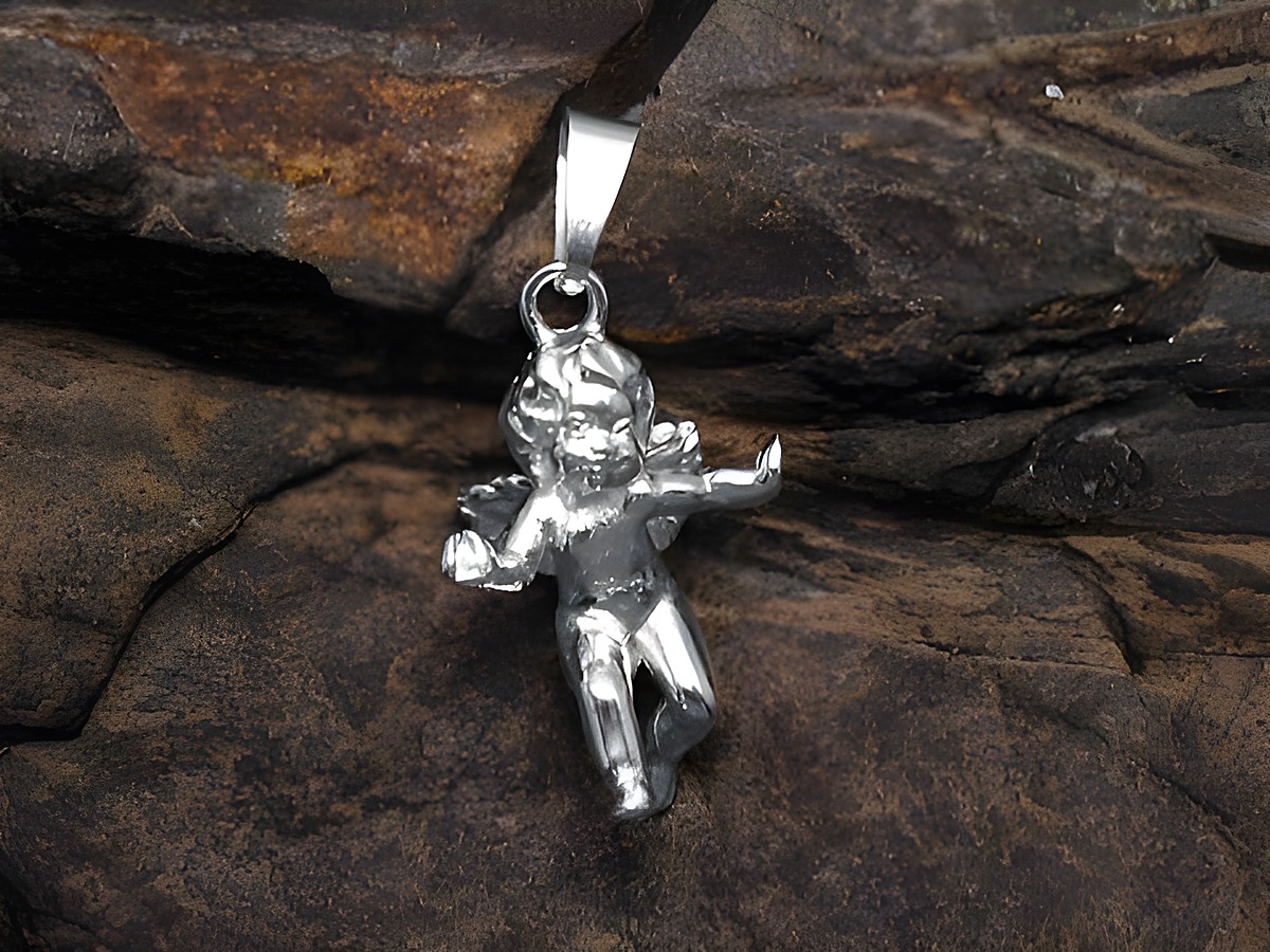 Ein plastischer Anhänger eines Engels aus 925 Sterling Silber, detailreich gestaltet und glanzvoll, präsentiert auf einer rustikalen Steinoberfläche.