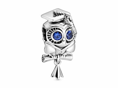 Silberner Pandora Charm in Form einer Eule mit einem Abschlusshut und blauen Kristallen. Die Eule hält eine Roulade mit einem Band, ideal für Graduation-Anlässe.