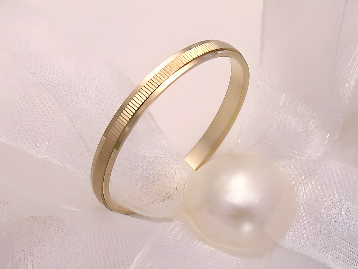 Freundschaftsring TENDERLY in Gold auf Silber, Größe 56/17,8, Hersteller Juwelier Harnisch, zierlich und elegant, sitzend auf einem weißen Stoff mit einer Perle.