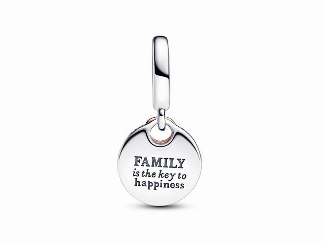 Doppelter Charm-Anhänger von Pandora in Silber und Roségold Vergoldung mit klaren Zirkonia, zeigt eine runde Medaille mit Gravur "Familie ist der Schlüssel zum Glück".