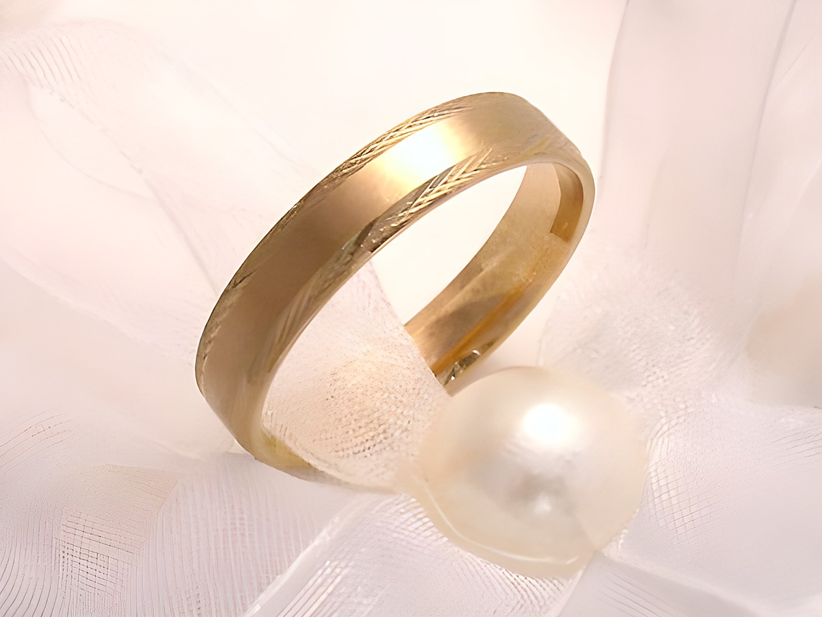 Trauring Ehering ENDLESS aus Gold 333 in Größe 55,5/17,6, Hersteller Juwelier Harnisch, elegant auf einem weißen Tuch mit einer Perle arrangiert, bis Größe 56/17,8 erhältlich.