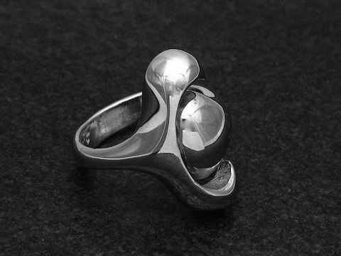 Silberring von Juwelier Harnisch in rhodiniertem Finish, modernes Design ohne Stein, wenig verstellbar, elegante Form mit glänzenden Oberflächen.