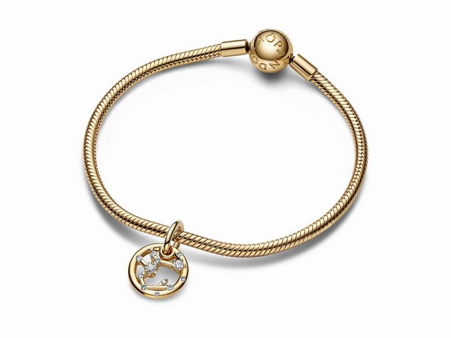 Der Charm-Anhänger von Pandora zeigt das Sternzeichen Schütze, gefertigt aus gelbgold vergoldetem Metall mit Zirkonia-Steinen, angebracht an einem eleganten Armband.