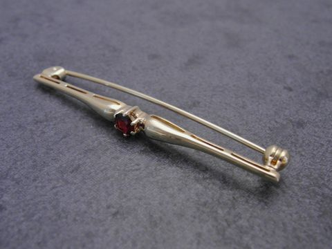 Gold Brosche edel Gold 333 Granat Anstecknadel Hersteller Juwelier Harnisch Broschen dekorative, geschwungene Form mit rotem Granat und sicherem Verschluss. Ideal als elegantes Accessoire.