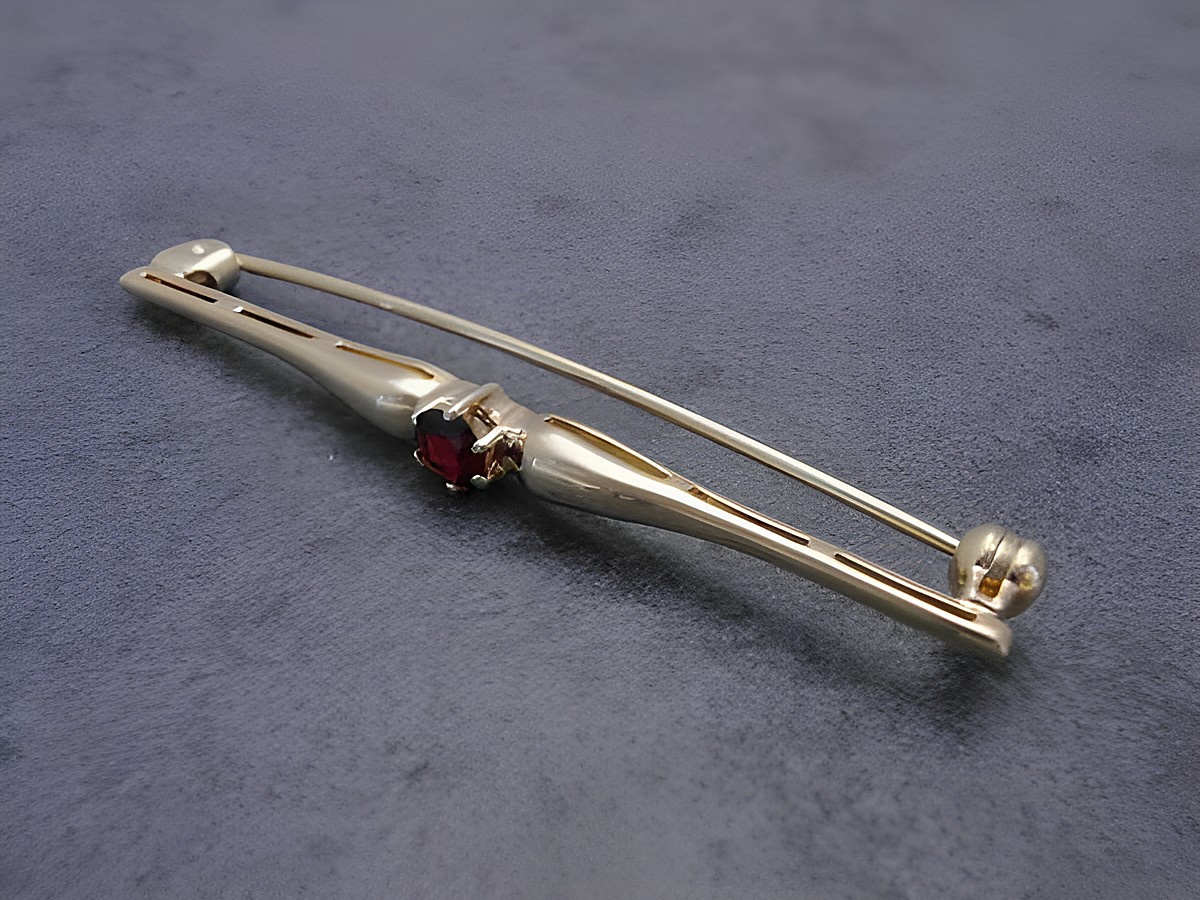 Gold Brosche edel Gold 333 Granat Anstecknadel Hersteller Juwelier Harnisch Broschen dekorative, geschwungene Form mit rotem Granat und sicherem Verschluss. Ideal als elegantes Accessoire.