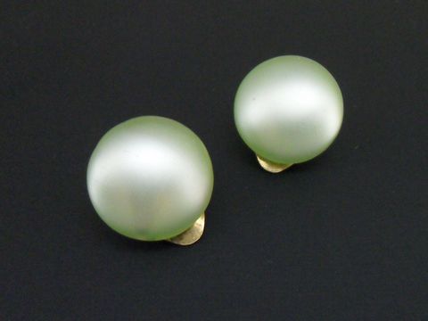 Ohrclip in schlichtem hellgrün mit goldfarbenem Detail und synthetischer Zuchtperle in seidenmatter Optik, Hersteller Juwelier Harnisch.