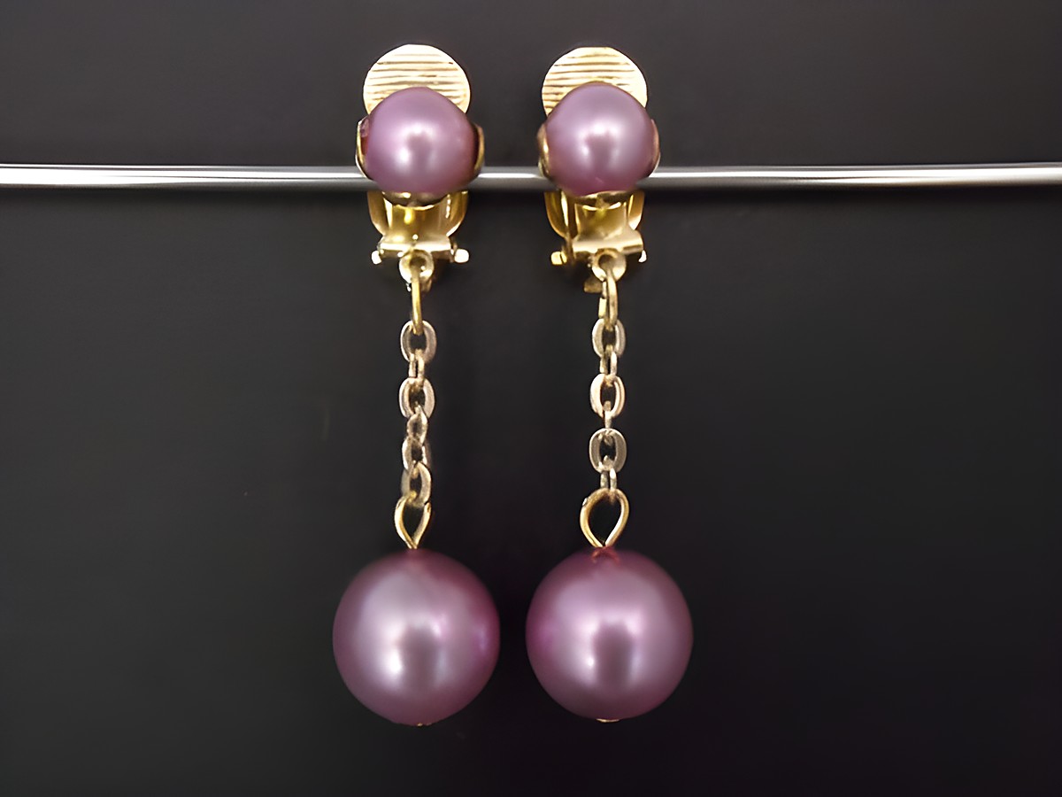 Hellrosa glänzende Ohrclips zeitlos aus Kunstharz mit goldfarbenen Elementen, hergestellt von Juwelier Harnisch, mit einem eleganten Design und asymmetrischen Perlenanhängern.