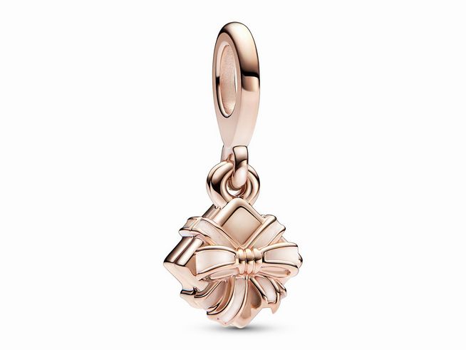 Das Bild zeigt einen Aufklappbaren Geburtstagsgeschenk Charm-Anhänger von Pandora in Roségold Vergoldung mit Emaille, der filigran gestaltet ist und eine Schleife aus einem Geschenk darstellt.