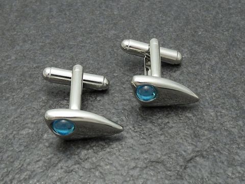 Designer Manschettenknöpfe in silberfarben mit hellblauen Akzenten, hergestellt von Juwelier Harnisch, elegant und modern im Design, ideal für besondere Anlässe oder das Büro.