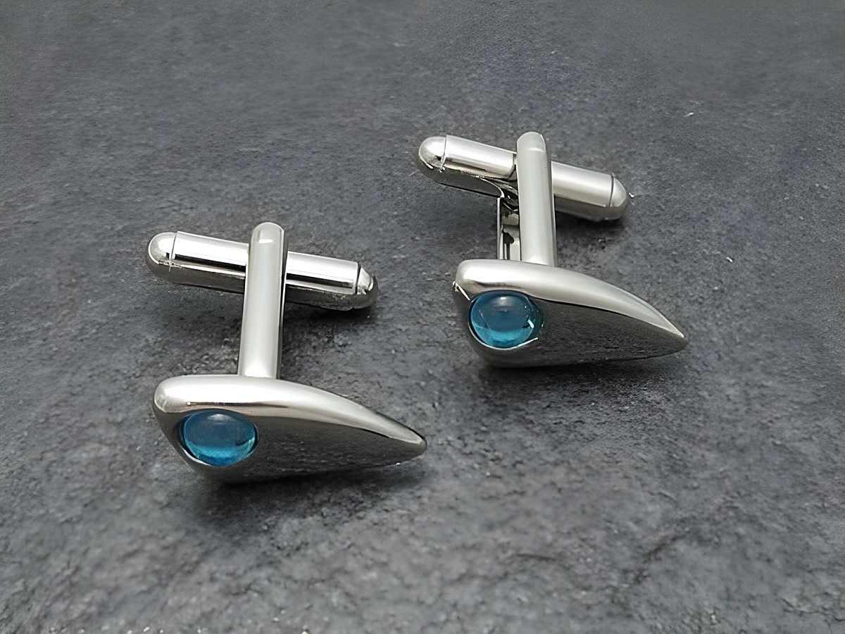 Designer Manschettenknöpfe in silberfarben mit hellblauen Akzenten, hergestellt von Juwelier Harnisch, elegant und modern im Design, ideal für besondere Anlässe oder das Büro.