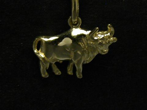 Ein plastischer Anhänger des Stiers aus poliertem Gold, hergestellt von Juwelier Harnisch, detailreich und glänzend, ideal für Sternzeichen-Liebhaber.