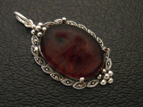 Cabochon Bernstein Silber Medaillon Anhänger in filigraner Ausführung, Hersteller Juwelier Harnisch, mit kunstvoll gestaltetem Rahmen und ovalem Bernsteinstein, idealer Schmuck für Liebhaber.