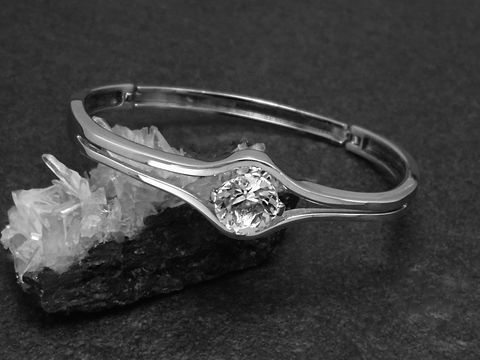 Silber Armreifen pompös 14,3 mm rhodiniert 17 cm von Juwelier Harnisch, elegant mit funkelndem Stein, stilvoll auf schwarzem Hintergrund präsentiert.