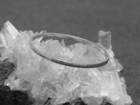 Silber Ring rhodiniert 1mm breit Größe 60 19mm von Juwelier Harnisch auf hellem Kristall-Hintergrund, zeitloses Design, ideal für jeden Anlass.