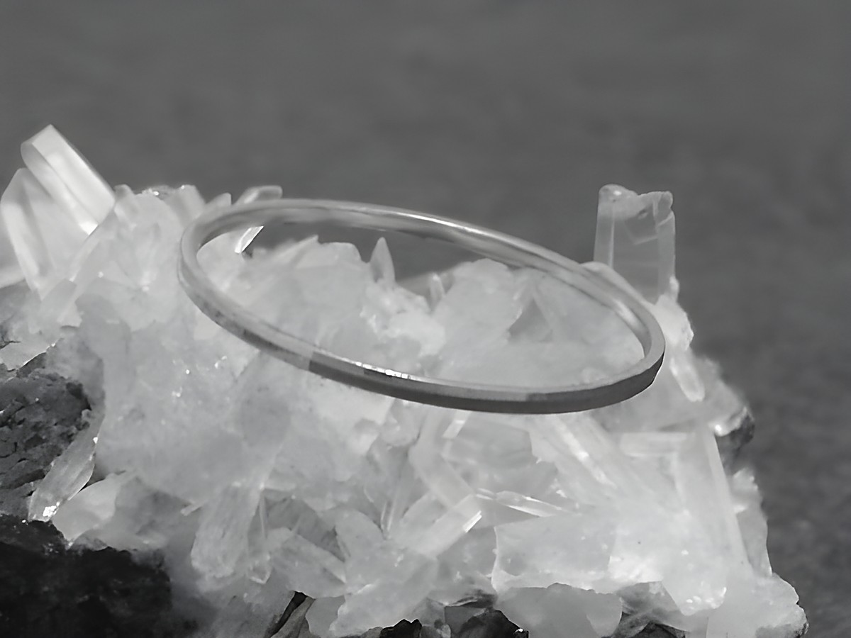 Silber Ring rhodiniert 1mm breit Größe 60 19mm von Juwelier Harnisch auf hellem Kristall-Hintergrund, zeitloses Design, ideal für jeden Anlass.