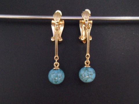 Ohrclip in zeitlosem Design mit echter Goldauflage und synthetischem Türkis. Hersteller: Juwelier Harnisch. Elegantes Schmuckstück mit hängendem Türkisanhänger.