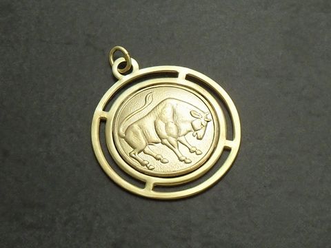 Goldfarbene, runde 3D-Platte mit dem Sternzeichen Stier, gestaltet von Juwelier Harnisch, zeigt einen detaillierten Stier im Inneren des kreisförmigen Rahmens.