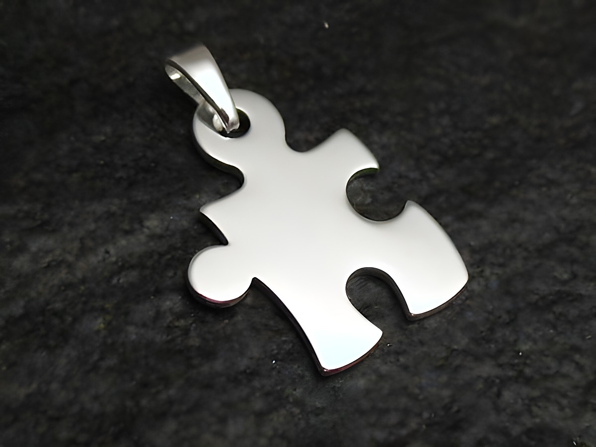 Sterling Silber Anhänger in Form eines Puzzlestücks, hochwertig verarbeitet, glänzende Oberfläche, hergestellt von Juwelier Harnisch, geeignet als modisches Accessoire oder Geschenk.