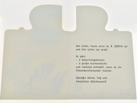 Geburtstagskarte mit einem niedlichen Bärchen und einer Torte, innen mit buntem Text zur Feier des zweiten Geburtstags, hergestellt von Juwelier Harnisch.