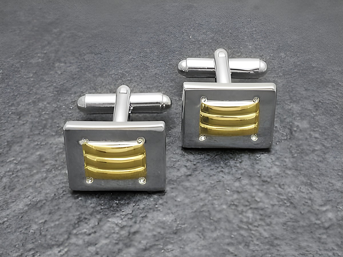Designer Manschettenknöpfe in Bi-Color silber-goldfarben von Juwelier Harnisch, mit einem eleganten Design und silberfarbener Grundfarbe, ideal für festliche Anlässe.
