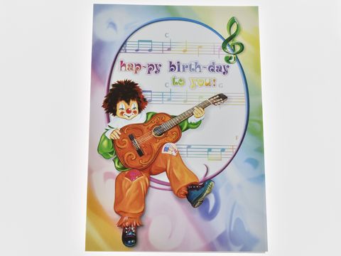 Eine bunte Geburtstagskarte zeigt einen Clown, der fröhlich eine Gitarre spielt. Im Hintergrund sind Noten und der Schriftzug Happy Birthday zu sehen. Hersteller: Juwelier Harnisch.