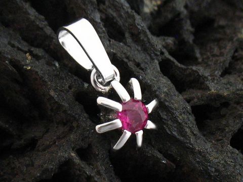 Silber Anhänger in Blumenform mit einem Rubin, rhodiniert. Hersteller: Juwelier Harnisch, echt Silber. Der Rubin schimmert in kräftigem Rot und wird von silbernen Blütenblättern umrahmt.