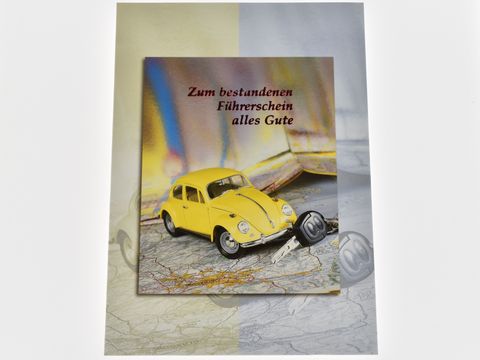 Gelbes Modellauto neben Autoschlüssel und Landkarte auf Glückwunschkarte zum bestandenen Führerschein, Hersteller Juwelier Harnisch.