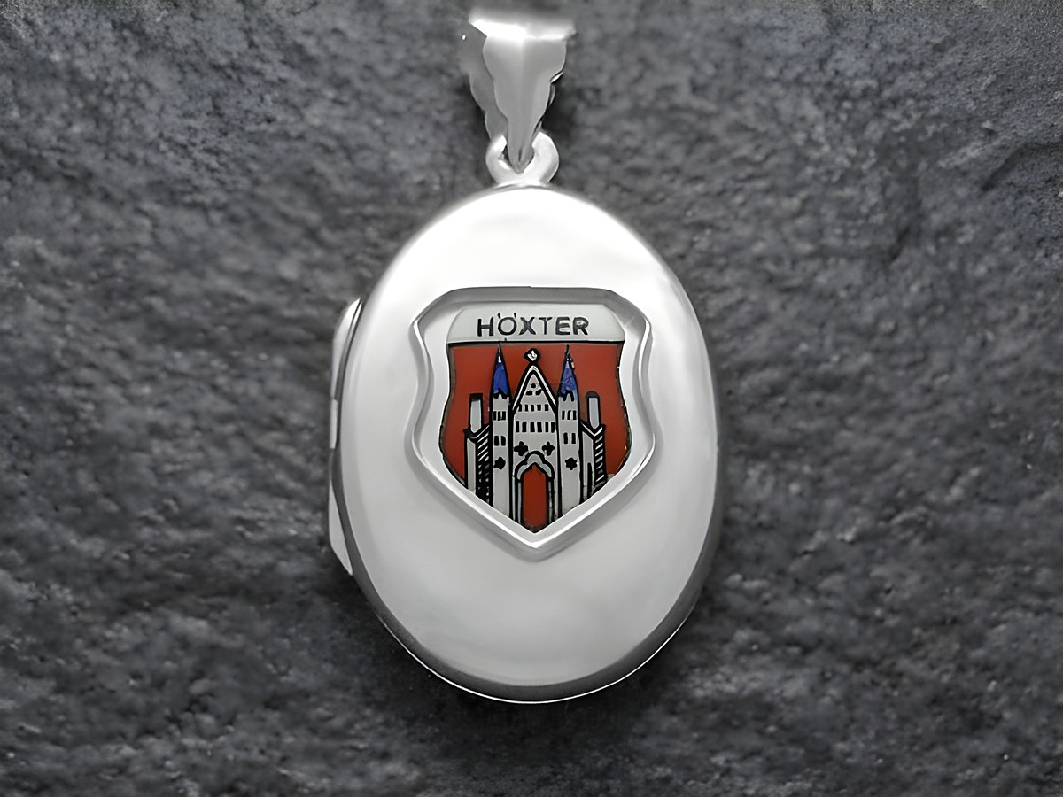 Ein silbernes Medaillon mit dem Wappen der Stadt Höxter, das ein rot-weißes Schild mit einem historischen Gebäude zeigt. Hersteller ist Juwelier Harnisch aus Nordrhein-Westfalen.
