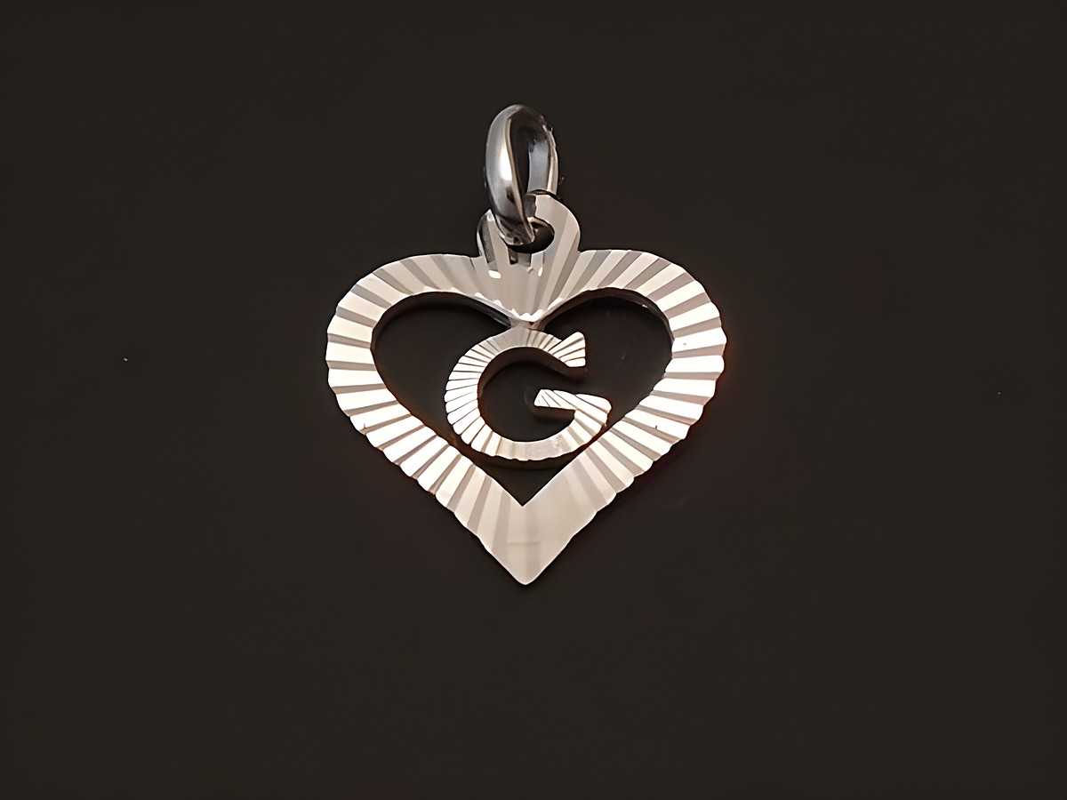 Herzförmiger Anhänger aus Sterling Silber rhodiniert mit eingeprägtem Buchstaben G, Hersteller Juwelier Harnisch, glänzende Oberfläche und dekorative Riffelung.