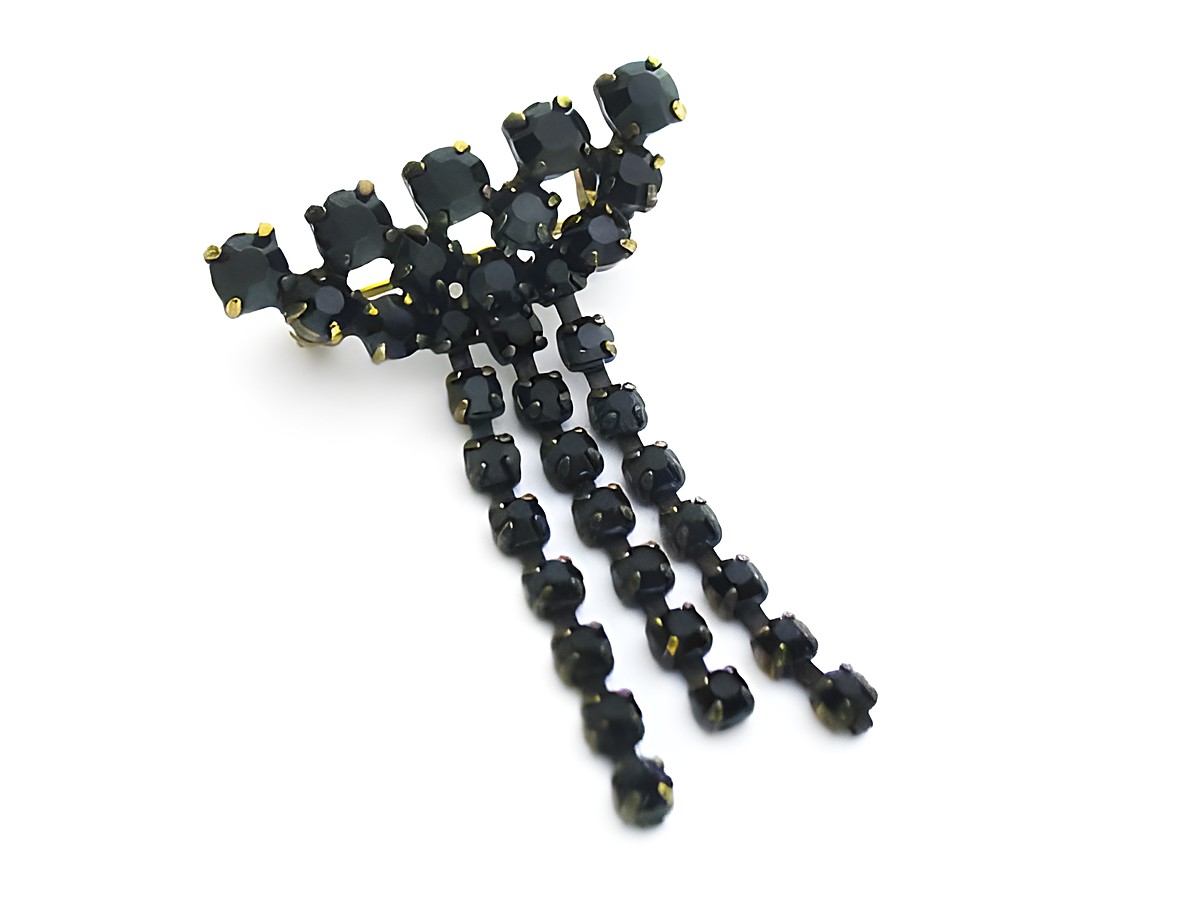 Schwarze Strass Brosche im sexy City Look mit funkelnden schwarzen Steinen, hergestellt von Juwelier Harnisch. Elegant und stilvoll, ideal für besondere Anlässe oder als modisches Accessoire.