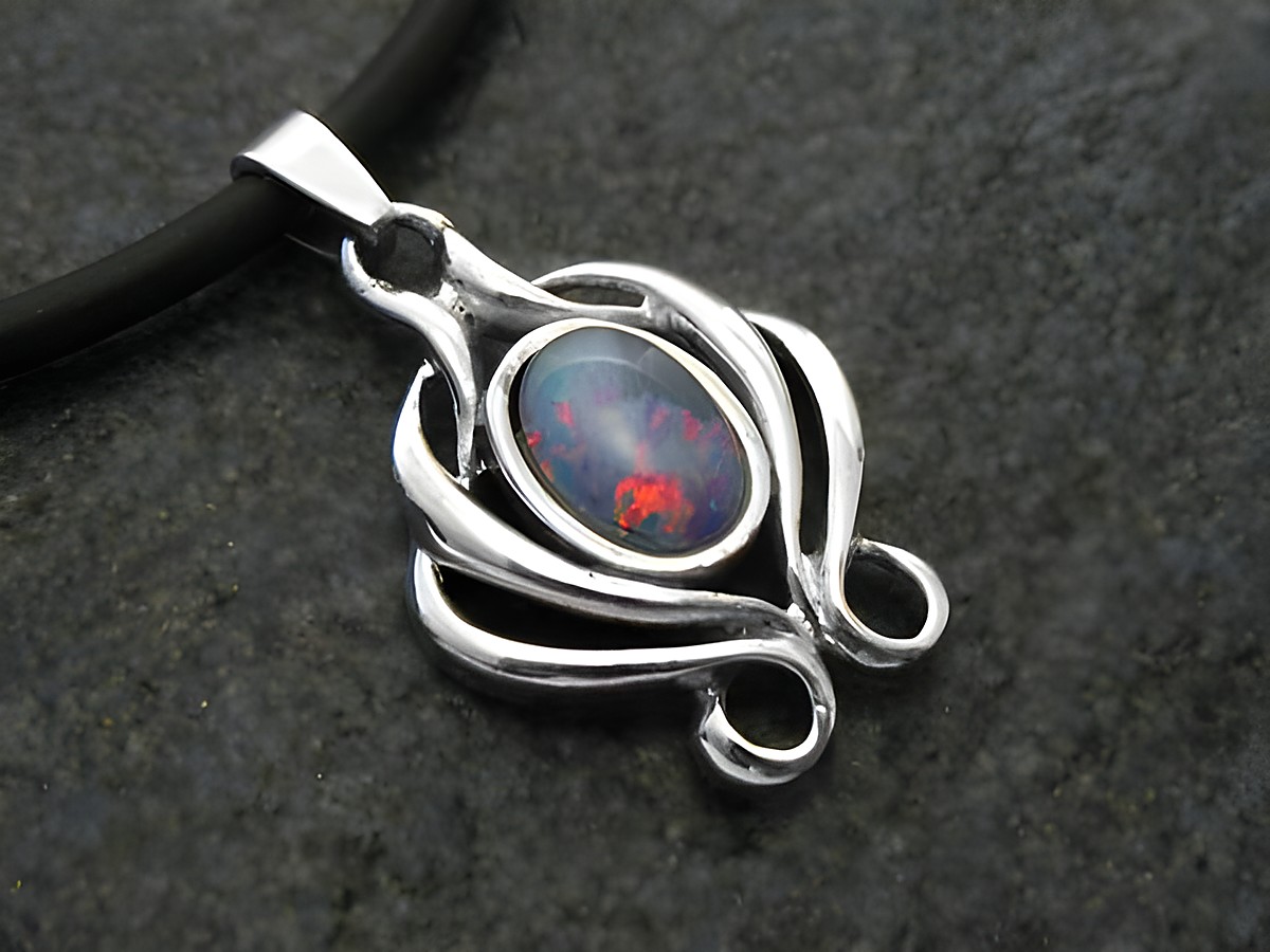 Nostalgischer Weißgold Anhänger mit einem wunderschönen Opal Triplette, umrahmt von filigranen Details, präsentiert auf einem dunklen Hintergrund. Hersteller Juwelier Harnisch.