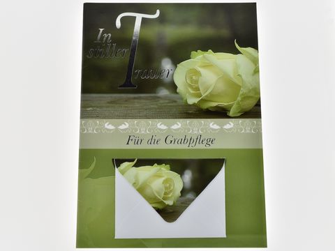 Trauerkarte mit Umschlag, auf grünem Hintergrund eine weiße Rose, der Text "In stiller Trauer" ist dekorativ platziert, darunter steht "Für die Grabpflege". Hersteller Juwelier Harnisch.