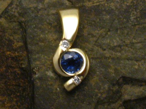 Eleganter Anhänger aus 585 Gold mit einem blauen Saphir und zwei kleinen Diamanten, hergestellt von Juwelier Harnisch. Ideal als Schmuckstück für besondere Anlässe.