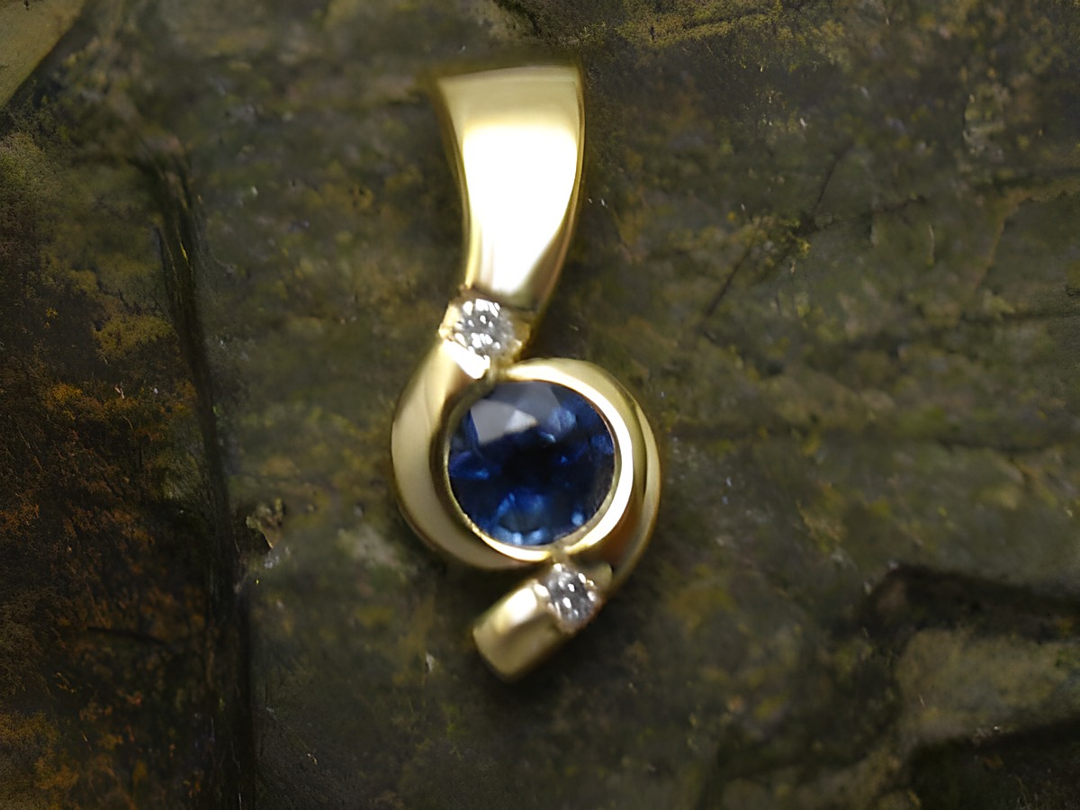 Eleganter Anhänger aus 585 Gold mit einem blauen Saphir und zwei kleinen Diamanten, hergestellt von Juwelier Harnisch. Ideal als Schmuckstück für besondere Anlässe.
