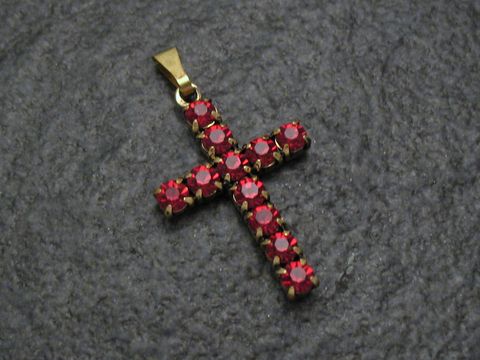 Roter Strass Anhänger mit sexy City Look in Kreuzform, hergestellt von Juwelier Harnisch, verziert mit funkelnden roten Strasssteinen, ideal für modische Akzente.