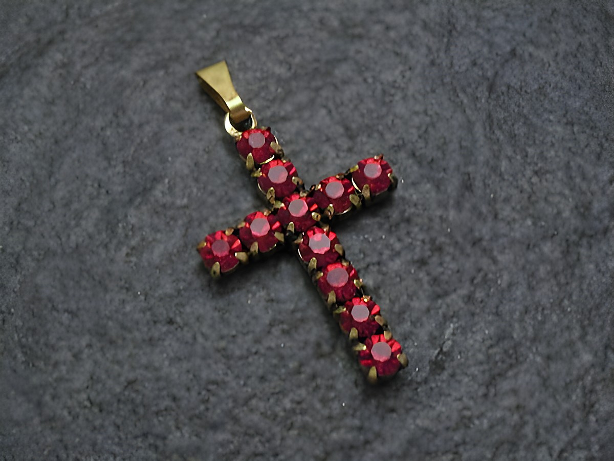 Roter Strass Anhänger mit sexy City Look in Kreuzform, hergestellt von Juwelier Harnisch, verziert mit funkelnden roten Strasssteinen, ideal für modische Akzente.