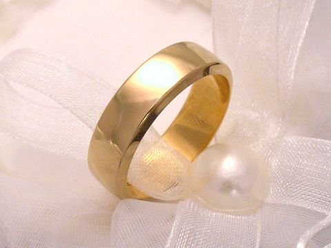 Ein moderner Trauring aus 585er Gold, schlicht und elegant, auf einem hellen Untergrund mit einer Perle und zarter Schleife. Größe 67,5/21,5, hergestellt von Juwelier Harnisch.