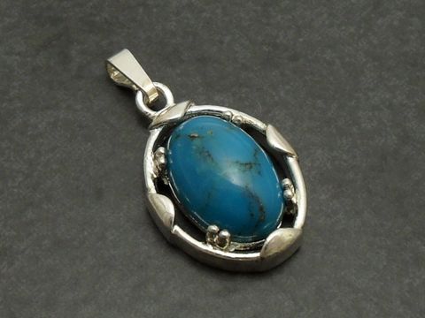 Designer Silber Anhänger in ovaler Form mit einem türkisfarbenen Stein, umgeben von einem filigranen Silberrand, Hersteller Juwelier Harnisch, ergänzt durch weitere Steine.