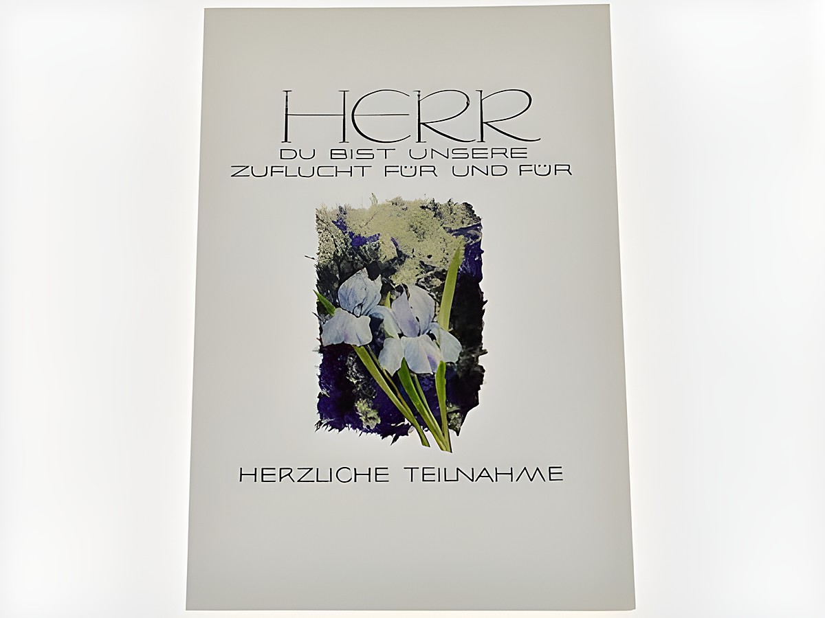 Ein Trauerkartenmotiv mit Blumen, auf einem hellen Hintergrund steht der Text Herr du bist unsere Zuflucht für und für. Darunter der Schriftzug herzliche Teilnahme. Hersteller Juwelier Harnisch.
