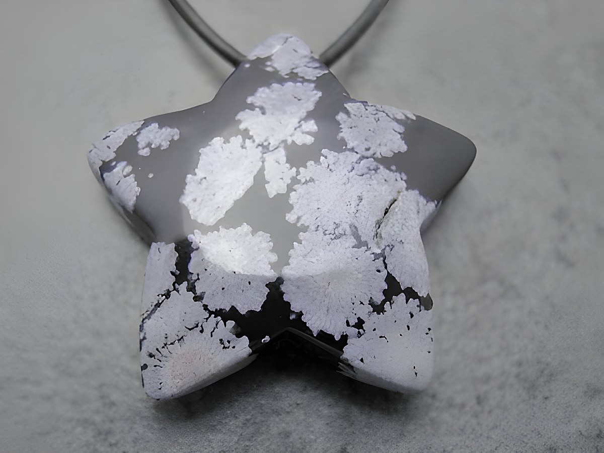 Schwarzer und grauer Sternanhänger aus Schneeflocken-Obsidian, geschliffen mit schneeweißen Einsprenkelungen, inklusive 1 Meter Lederband, gefertigt von Juwelier Harnisch.