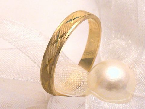 400284-0 Trauring Ehering CROSS aus Gold 333 in Größe 56/17,8, verziert mit feinen Mustern, elegant auf einem schlichten Untergrund drapiert neben einer Perle. Hersteller Juwelier Harnisch.