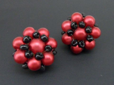Ohrclip in rot-schwarz mit blumigem Design, verziert mit goldfarbenen synthetischen Zuchtperlen, hergestellt von Juwelier Harnisch. Ideal für jeden Anlass.