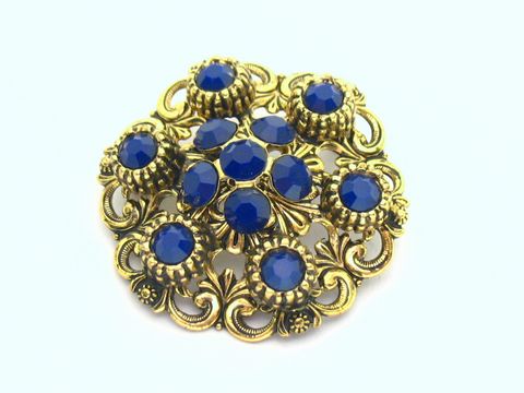 Damen Brosche im Sexy City Look in Blau, rund, mit goldfarbener Umrandung und mehreren blauen Steinen, Hersteller: Juwelier Harnisch, idealer Modeschmuck für elegante Anlässe.