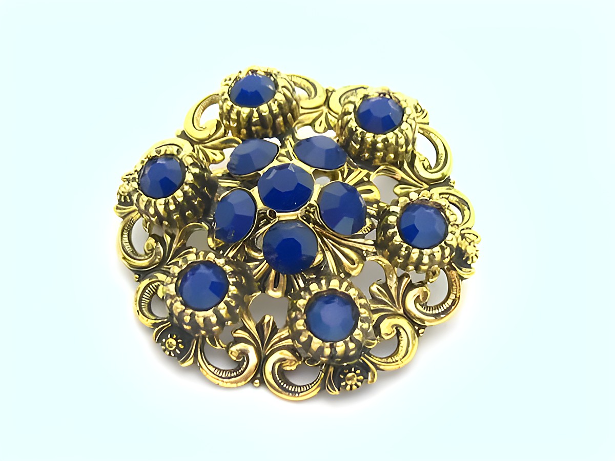 Damen Brosche im Sexy City Look in Blau, rund, mit goldfarbener Umrandung und mehreren blauen Steinen, Hersteller: Juwelier Harnisch, idealer Modeschmuck für elegante Anlässe.